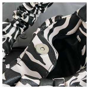 Close-up of zebra print PU leather bag showing magnetic closure and ruched handle texture