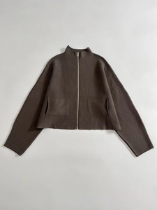 Detail of dark coffee zip-up knit cardigan showing smooth texture and metal zipper