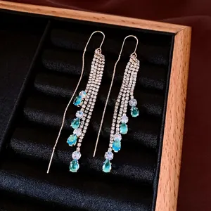 Elegant gold drop earrings with blue cubic zirconia and layered diamond tassels