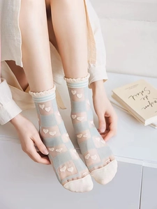 Detail of light blue sheer socks with heart embroidery and breathable mesh texture