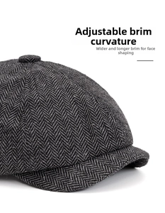 Detail of grey herringbone tweed newsboy cap with a wide bendable and foldable brim