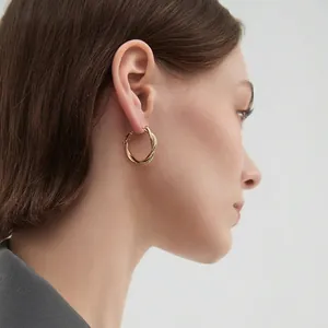 Minimalist gold twisted hoop earrings for women with a sleek mirror finish surface