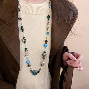 Detailed view of bohemian layered beaded necklace with turquoise stones and butterfly pendant