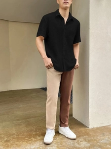 Detail of men's short sleeve shirt with seersucker texture and color block casual pants