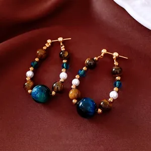 Boucles d'oreilles créoles vintage avec œil de tigre et perles sur fond de soie