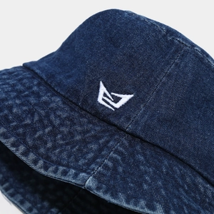 Macro detail of high-quality white embroidery on washed denim bucket hat with retro texture