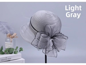 Detail of light gray organza hat with elegant mesh bow and stylish spiral weave texture