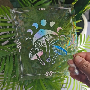 Detail showing hand-held holographic mushroom and moon phase prism suncatcher window sticker