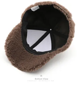 Detailed bottom view showing brown plush fabric, black lining and white care label of the hat