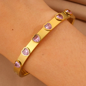 Vue détaillée du bracelet doré en acier inoxydable orné de zircons roses en forme de cœur