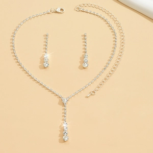 Macro shot of silver wedding jewelry set with Y-shaped necklace and drop earrings