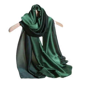 Eleganter dunkelgrüner Seidenschal mit Farbverlauf an einem Holzkleiderbügel