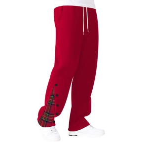 Détail du jogging rouge avec fentes latérales boutonnées et doublure à carreaux vert et rouge