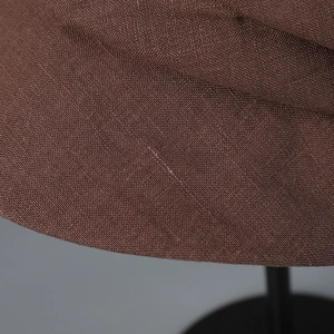 Gros plan du chapeau de soleil en lin marron montrant la texture fine du tissu et la couture