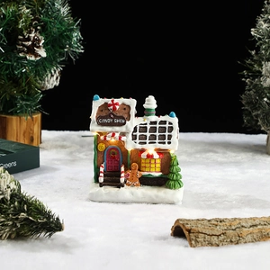 Close-up of lighted LED resin gingerbread candy shop with snowy Christmas decor