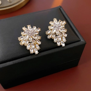 Macro shot of sparkling crystal flower stud earrings on black luxury velvet display