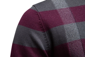 Gros plan sur l'épaule et la couture d'un pull rayé bordeaux et gris anthracite