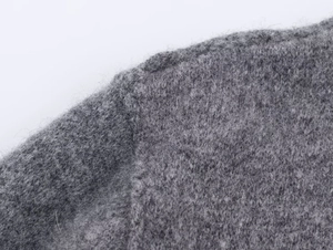 Dettaglio cucitura spalla e trama in morbida lana su cappotto grigio moda
