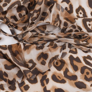 Detailed macro view of leopard print mesh fabric with ruffled edges and tie-up design