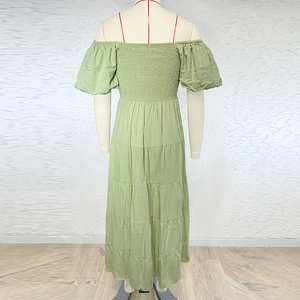 Detail of light green off-shoulder dress featuring puff sleeves and smocked waist texture