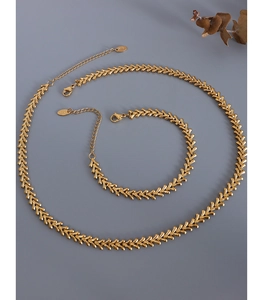 Macro shot of 18k gold leaf-shaped chain necklace and bracelet jewelry set