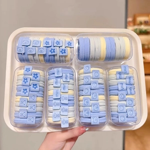 Detail of assorted pastel blue elastic hair ties with cute charms in display boxes