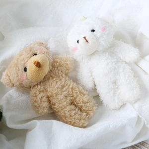 Detailed view of light brown and cream plush teddy bears with curly fur and pink blush