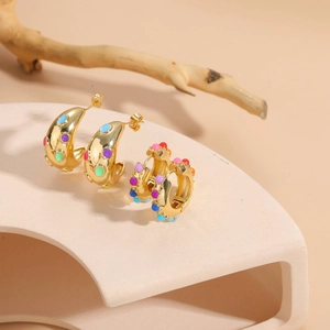 Detail of 14K gold plated earrings set with colorful enamel dots on geometric stands