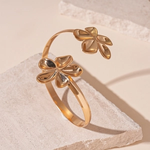Présentation artistique d'un bracelet manchette fleur dorée sur pierre texturée
