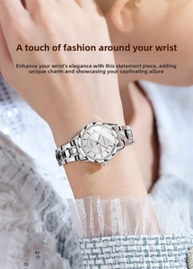 Close-up of silver stainless steel watch with faceted bezel and date display on wrist