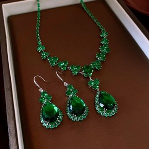 Detail of vintage emerald waterdrop jewelry set with necklace and earrings in a box