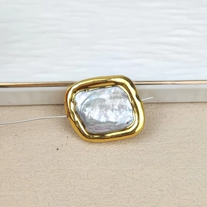 Macro detail of natural freshwater pearl with gold-plated square frame for DIY jewelry