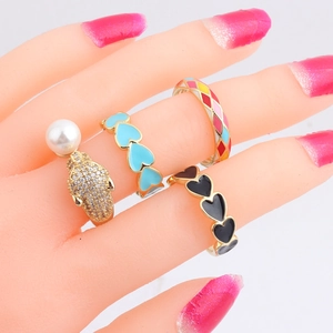 Set of four geometric enamel rings with pearls and diamonds on a gold-tone band