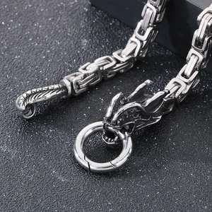 Macro shot of silver stainless steel dragon head clasp and square woven chain link