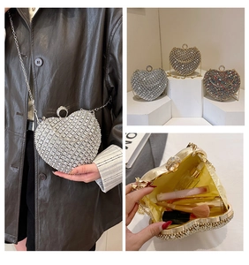 Detail view of heart-shaped rhinestone evening bag showing interior space for makeup items
