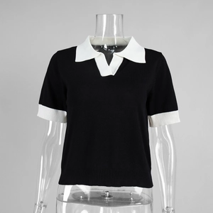 Gros plan sur le col polo contrasté et la texture tricotée noire du haut ajusté