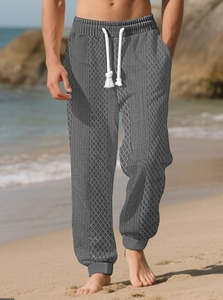 Détail du pantalon d'été gris pour hommes avec motif tricot et cordon blanc sur la plage