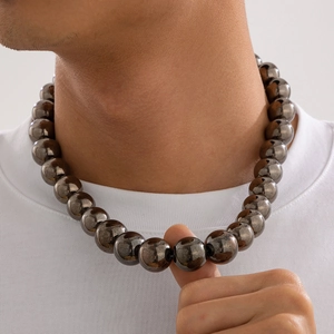 Close-up of men's chunky metallic round bead necklace in bold hip-hop streetwear style