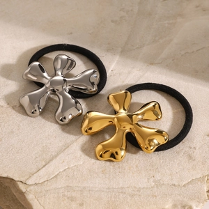 Floral stainless steel hair ties in gold and silver finish on a natural stone surface