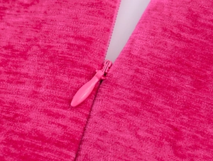 Makro-Detail des rosa Chenille-Stoffs mit vertikaler Streifenstruktur und Reißverschluss