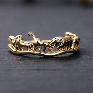 Macro detail of golden circus animal relief ring with elephants and lions on black stone