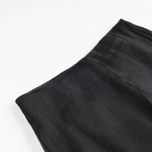 Close-up of black pleated fabric detail with fine texture on early spring short dress