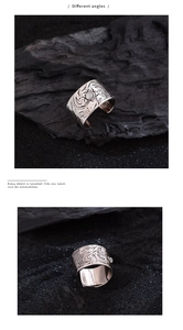 Macro detail of silver wide ring featuring intricate floral engraving and moonstone inlay