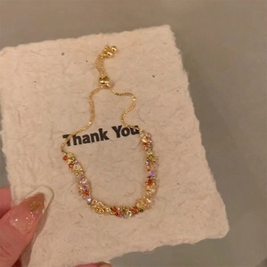 Gros plan de perles colorées et bracelet chaîne en or sur une carte cadeau Thank You