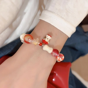 Detail of beaded bracelet with red apple core pendant and crystal stars on wrist
