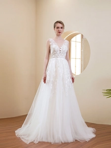 Close-up of deep V-neck lace embroidery and floral details on a white wedding dress