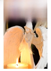 Macro shot of praying angel candle holder showing detailed white resin feather wings
