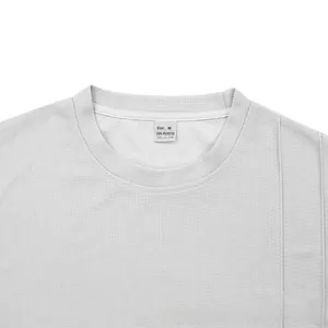 Close-up of breathable honeycomb mesh fabric on grey t-shirt with size M inner label
