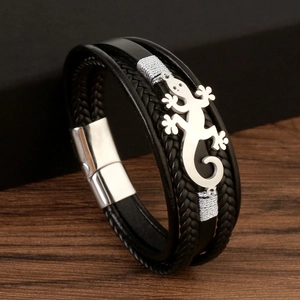 Macro detail of men's black woven leather bracelet with silver lizard charm and magnetic clasp