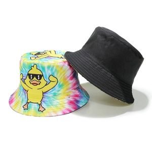 Detail of tie-dye and black reversible sun hats with cartoon yellow duck embroidery